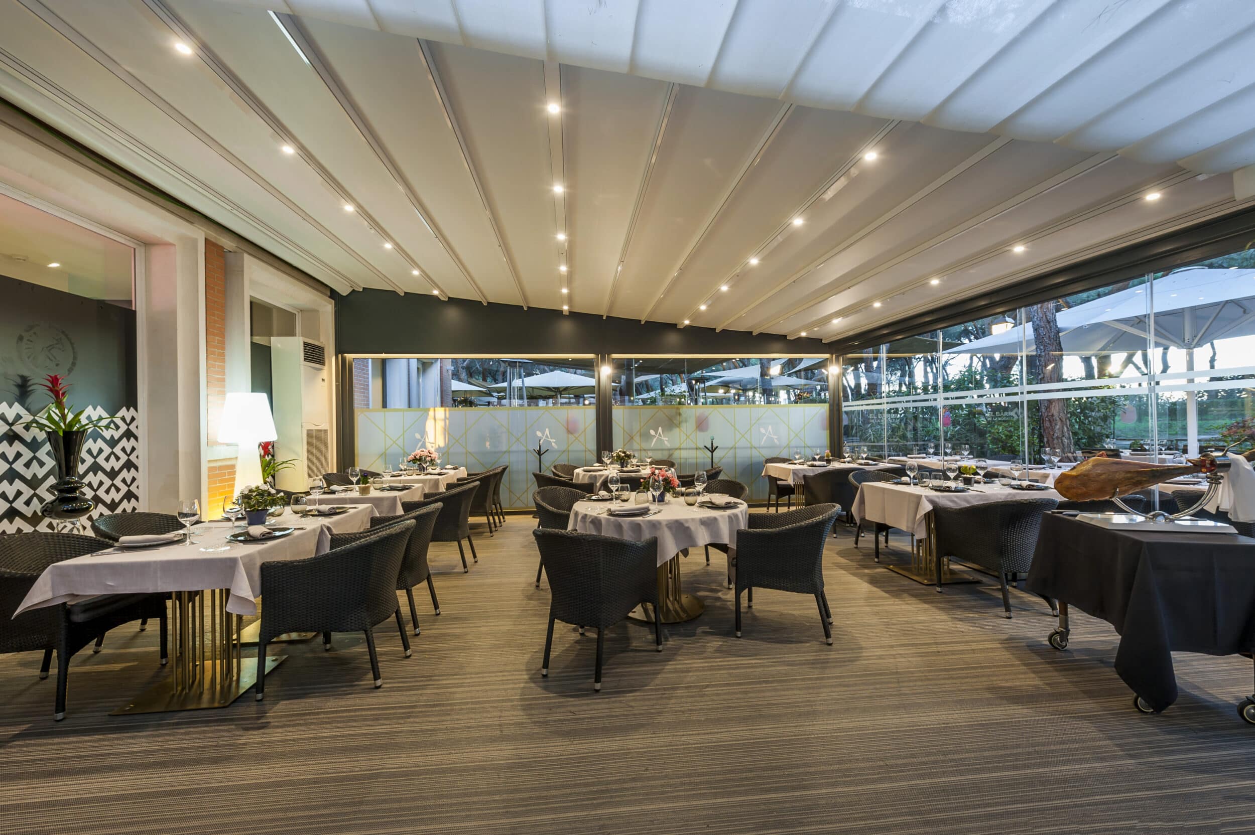 Techos de lona tensada abierto con iluminación led en la terraza de un restaurante.