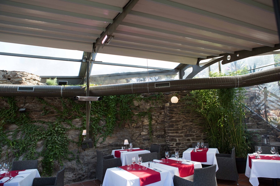 Sistema de cerramiento con techo de lona tensada a medida en la terraza de un restaurante