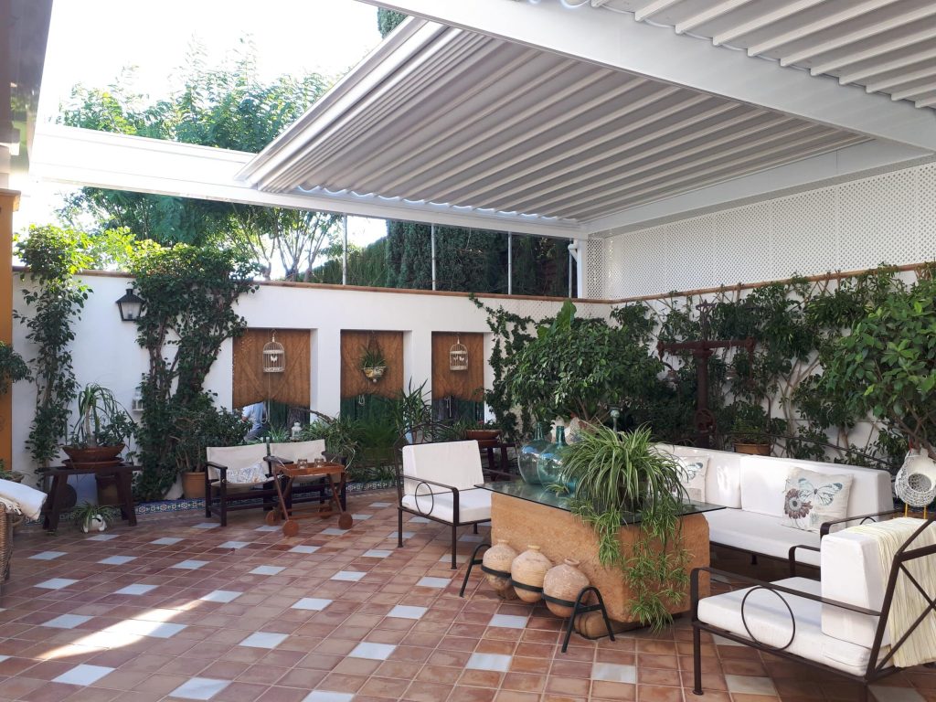 Sistema de cerramiento con techos de lona tensada en el patio de una vivienda de estilo andaluz.