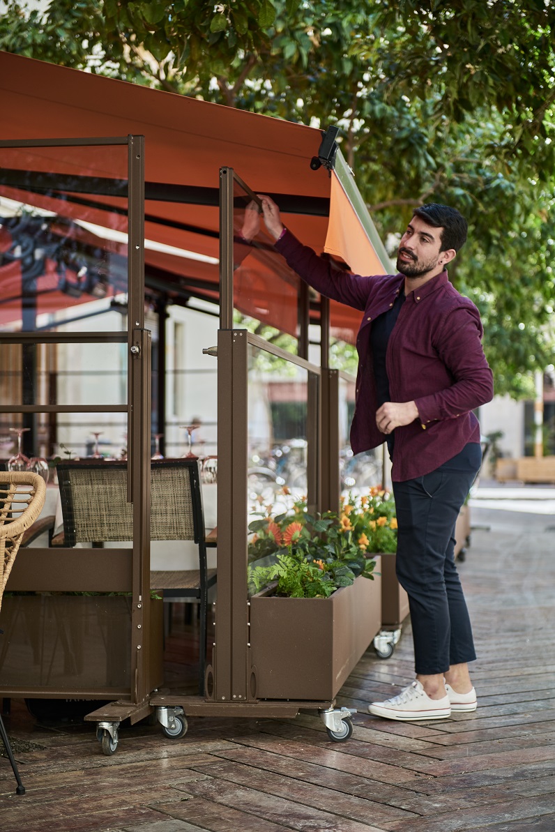 Paravientos de cristal en hostelería plegable accionado por el dueño del restaurante por el molesto viento que hay